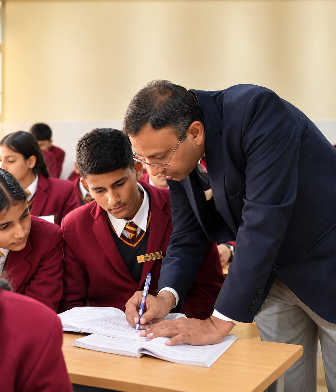 A teacher leaning in to help at a desk
