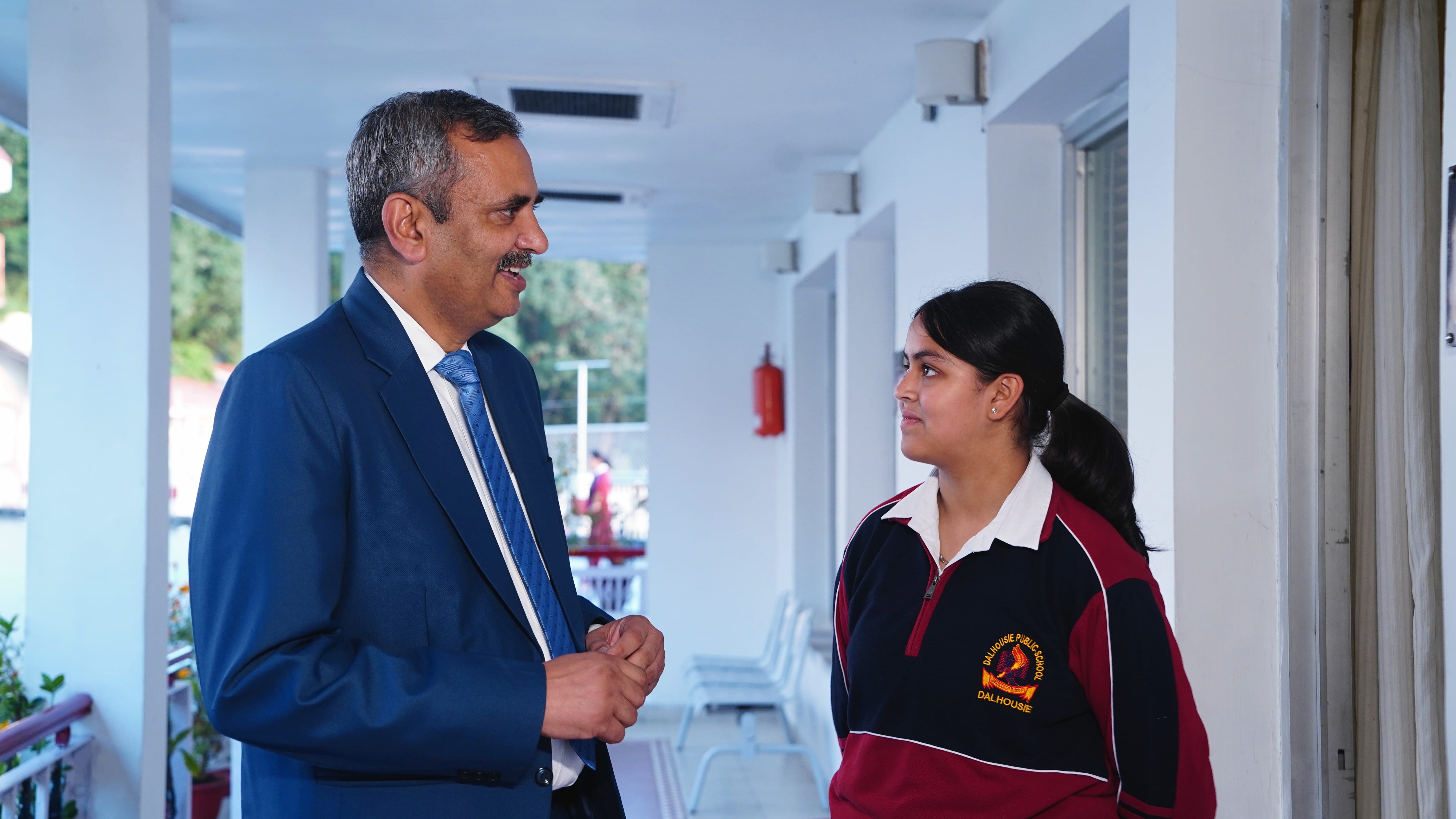 A teacher in conversation with a student on the corridor